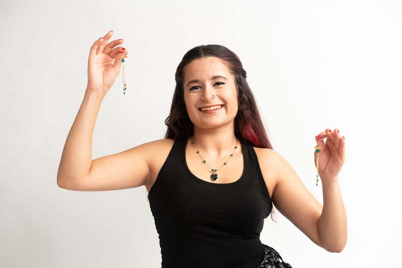 woman wearing beaded necklace holding earrings